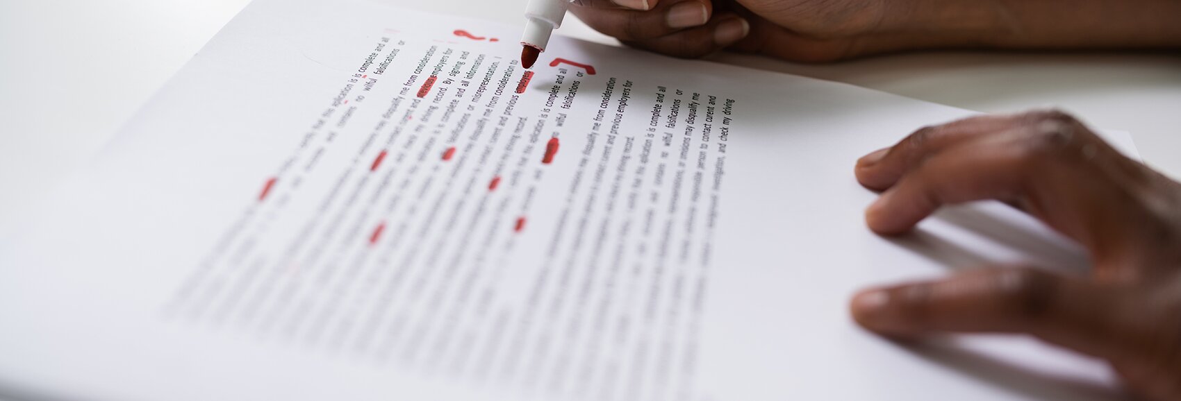someone is marking a text with a red pen